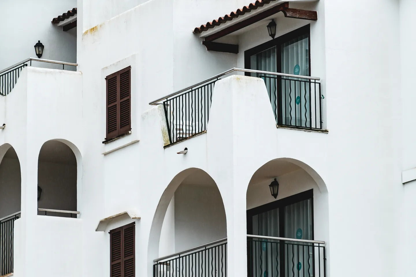Fachada blanca con arcos y balcones de estilo mediterráneo